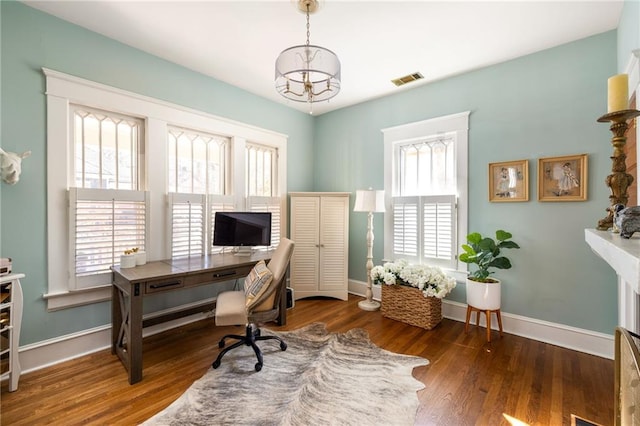 office area featuring a notable chandelier, baseboards, visible vents, and wood finished floors