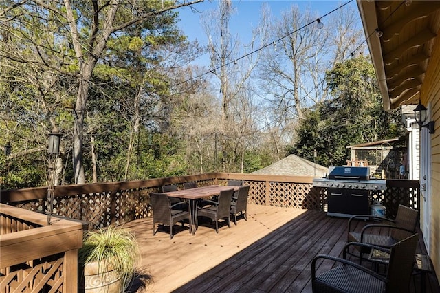 deck with grilling area and outdoor dining space