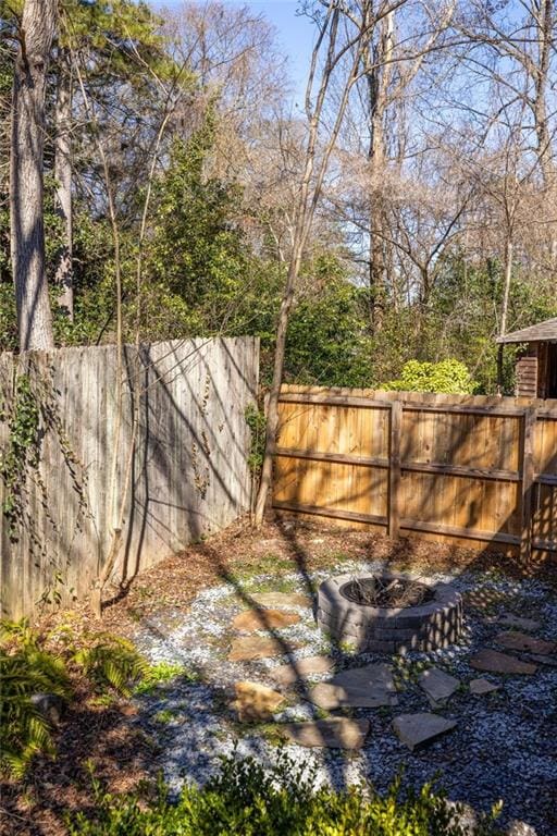 view of yard with an outdoor fire pit and fence