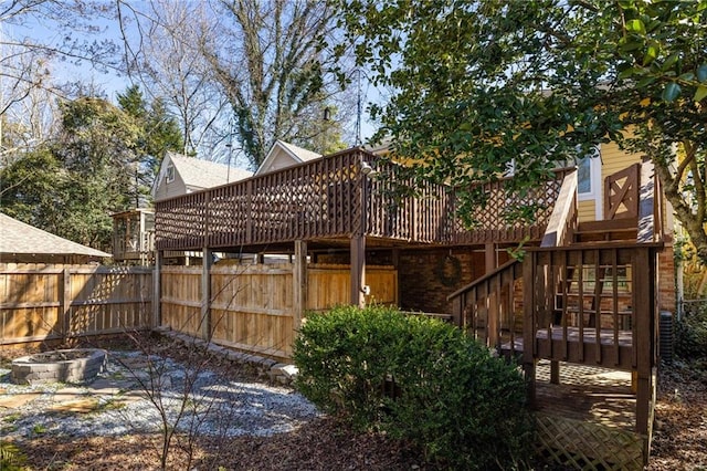 back of house with brick siding, stairway, fence, and a wooden deck