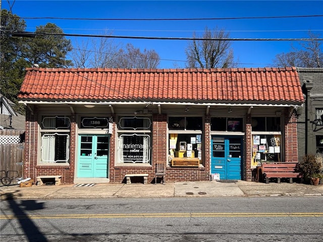 view of front of home featuring brick siding and a tile roof