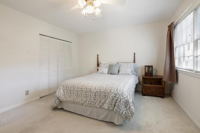 bedroom with a ceiling fan, a closet, multiple windows, and carpet