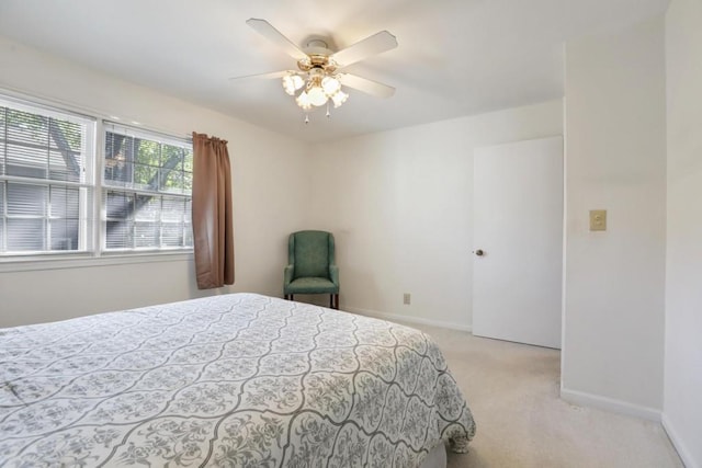 bedroom featuring light carpet, baseboards, and ceiling fan