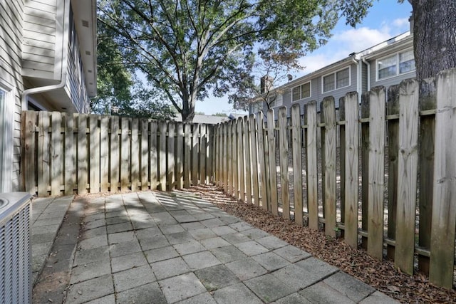 view of patio / terrace featuring central air condition unit and fence