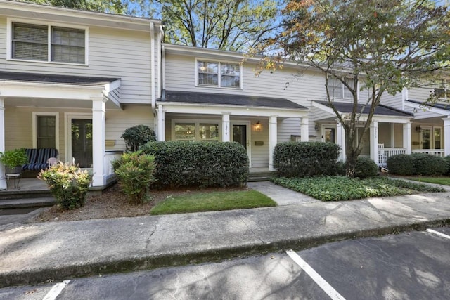 townhome / multi-family property featuring a porch and uncovered parking
