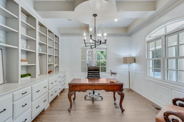 office space featuring a wealth of natural light, an inviting chandelier, and light hardwood / wood-style floors