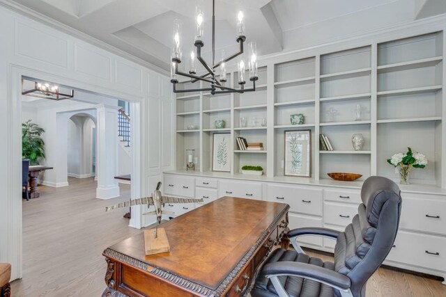 office area featuring a chandelier, decorative columns, and light hardwood / wood-style floors