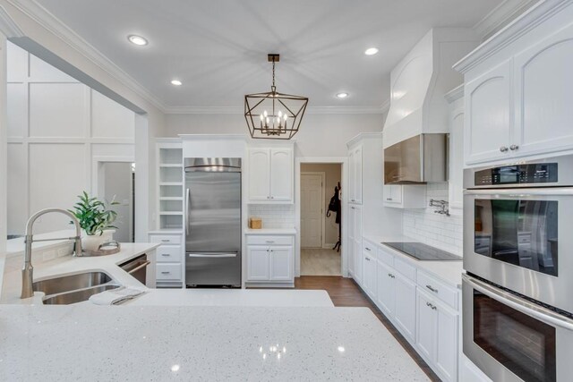 kitchen with stainless steel appliances, sink, light stone countertops, hanging light fixtures, and white cabinets