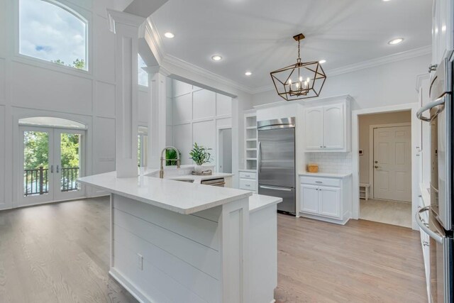 kitchen with french doors, light hardwood / wood-style flooring, white cabinetry, and built in refrigerator