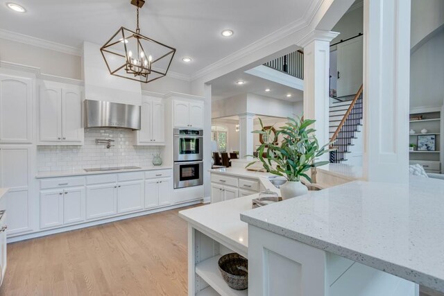 kitchen with pendant lighting, stainless steel double oven, black electric cooktop, ornate columns, and white cabinets