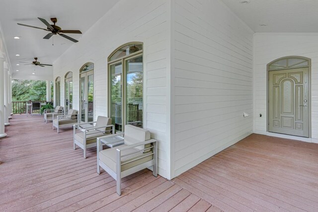 wooden terrace featuring an outdoor living space and ceiling fan