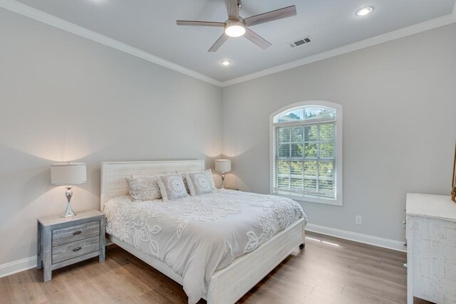 bedroom with ornamental molding, hardwood / wood-style floors, and ceiling fan