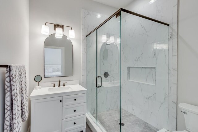 bathroom with walk in shower, toilet, and vanity