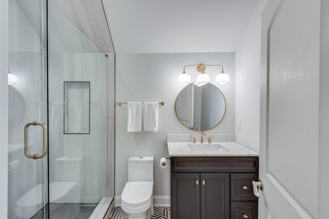 bathroom featuring vanity, toilet, and a shower with door