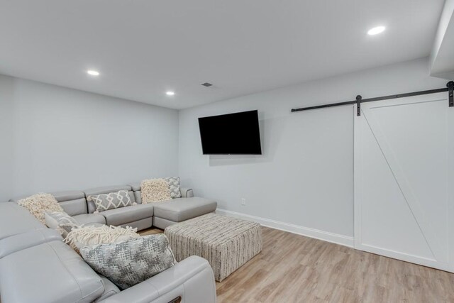 living room with light wood-type flooring and a barn door