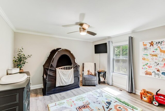 bedroom featuring crown molding, ceiling fan, and light wood-type flooring