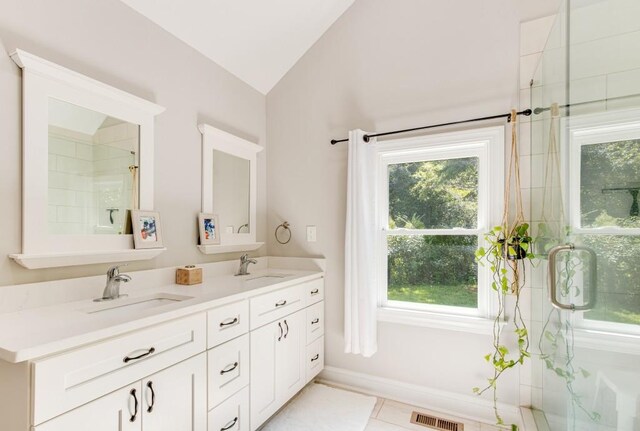 bathroom featuring tile patterned floors, a shower with shower door, vanity, and vaulted ceiling