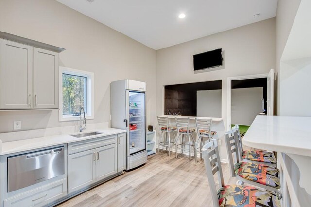 kitchen with light hardwood / wood-style flooring, sink, and dishwasher