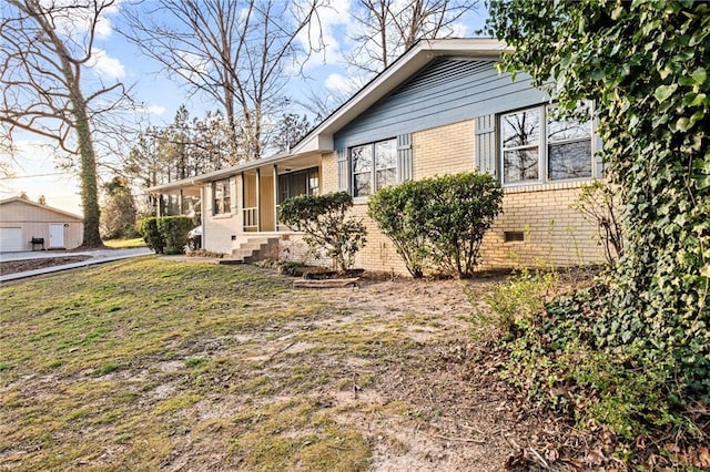 view of side of property with crawl space, brick siding, and a lawn