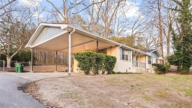 view of home's exterior with fence, aphalt driveway, and brick siding