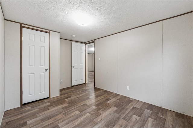 unfurnished bedroom with wood finished floors and a textured ceiling