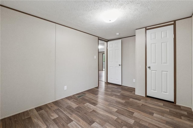 unfurnished bedroom featuring wood finished floors and a textured ceiling