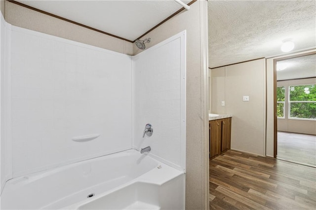full bathroom featuring vanity, wood finished floors, tub / shower combination, and a textured ceiling