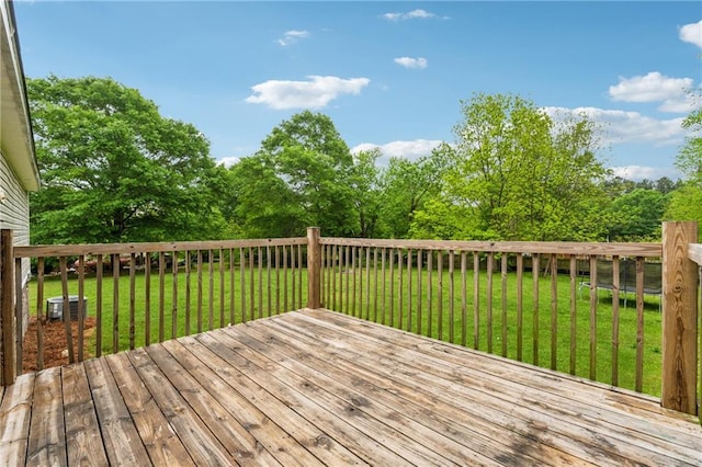 wooden terrace featuring a lawn and cooling unit