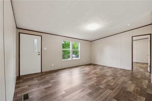 unfurnished living room with visible vents, wood finished floors, and a textured ceiling