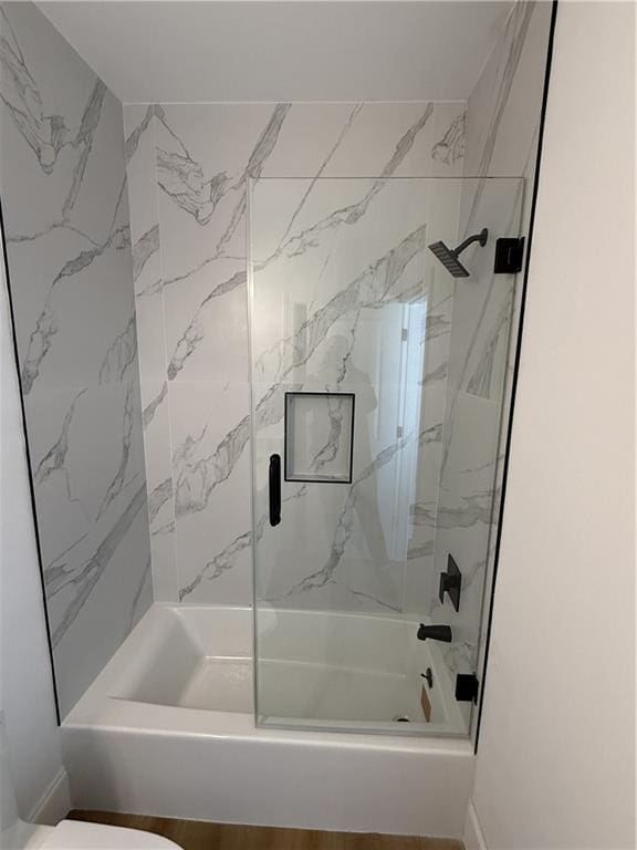 bathroom featuring toilet and tiled shower / bath combo