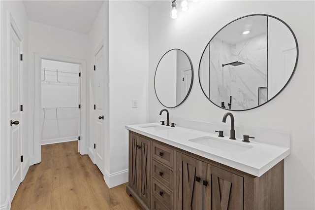 bathroom featuring walk in shower, vanity, and hardwood / wood-style floors