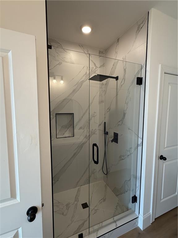 bathroom featuring a shower with door