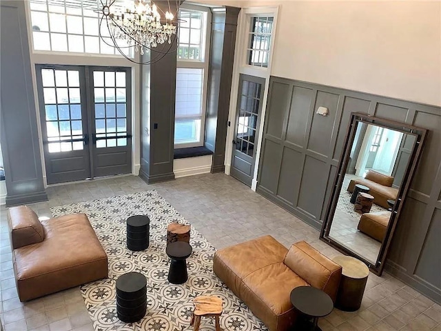 doorway to outside with french doors, a towering ceiling, and a chandelier