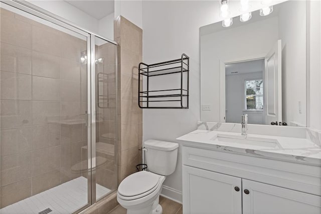 bathroom with an enclosed shower, vanity, and toilet