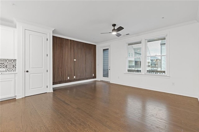 empty room featuring ceiling fan, wood-type flooring, and crown molding