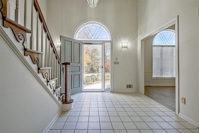 tiled entrance foyer with a healthy amount of sunlight and a high ceiling