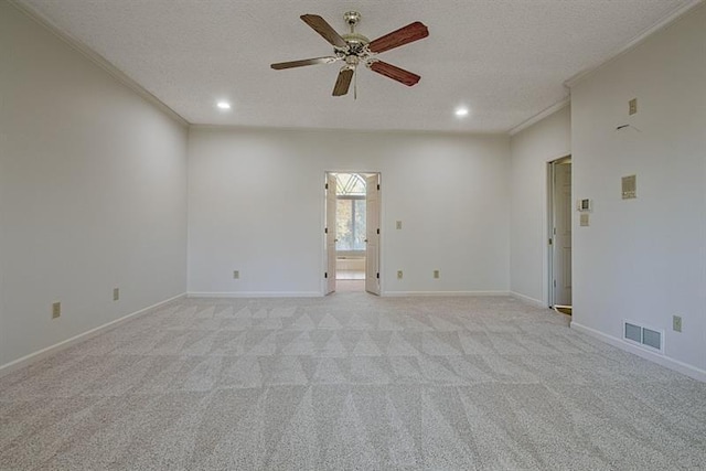 carpeted empty room featuring crown molding, ceiling fan, and a textured ceiling