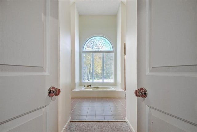 bathroom featuring tile patterned flooring and tiled tub