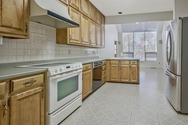 kitchen featuring backsplash, stainless steel refrigerator, kitchen peninsula, and white range with electric stovetop