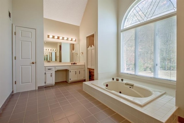 bathroom featuring high vaulted ceiling, tile patterned flooring, vanity, a relaxing tiled tub, and a textured ceiling