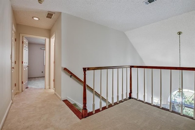 hallway with carpet and a textured ceiling