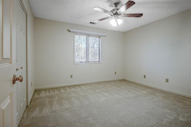 carpeted spare room with ceiling fan and a textured ceiling