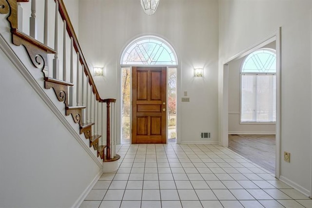 tiled foyer entrance with a towering ceiling and plenty of natural light