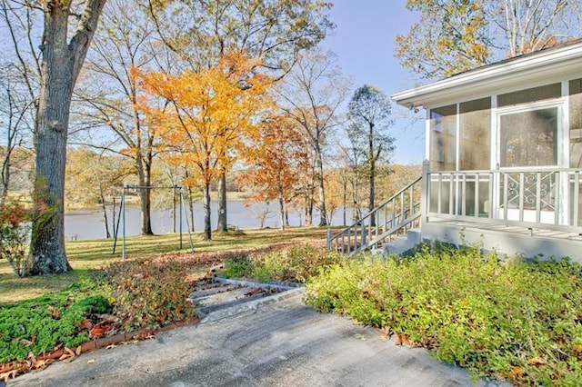 view of yard featuring a water view and a sunroom