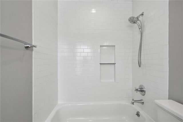 bathroom featuring toilet and tiled shower / bath combo