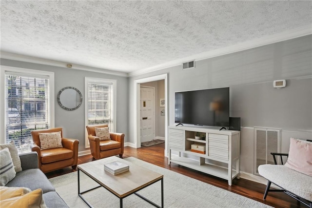 living room with crown molding, wood-type flooring, and a textured ceiling