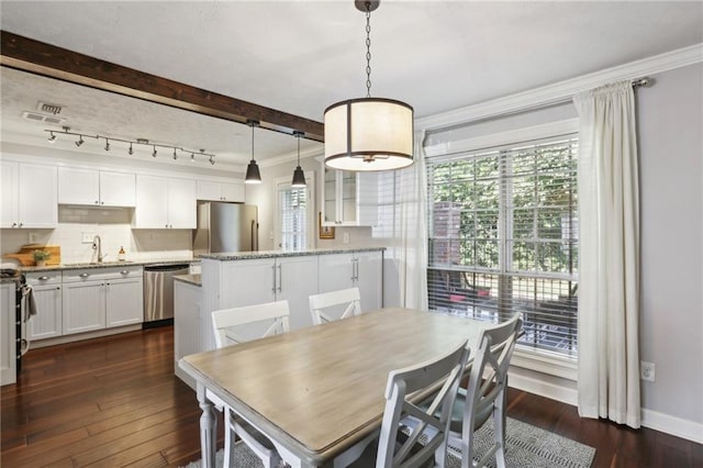 dining room featuring ornamental molding, sink, dark wood-type flooring, and rail lighting