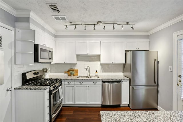 kitchen with light stone counters, sink, white cabinetry, stainless steel appliances, and crown molding