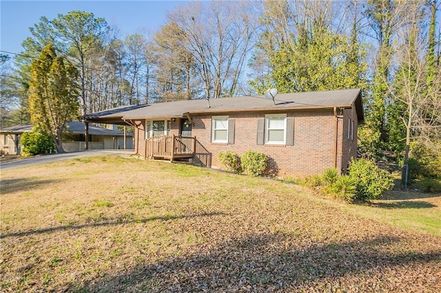 view of front of house featuring a carport, aphalt driveway, brick siding, and a front lawn