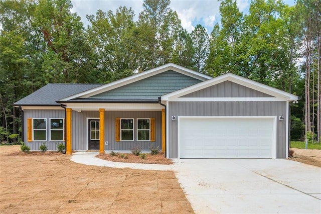 view of front of property with a garage, a porch, and concrete driveway